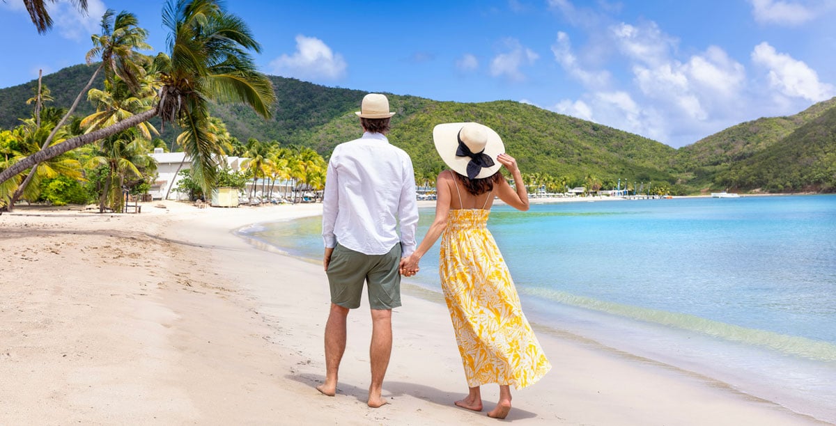 Couple walking on beach on sunny day