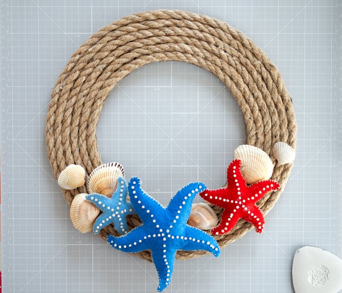 Wreath of rope with red and blue sea and sea shellsstars made of felt.