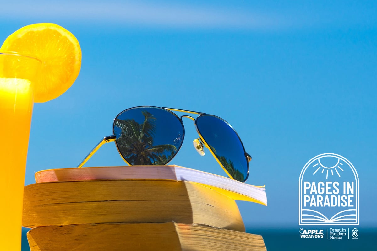 Stack of books on the beach with cocktail