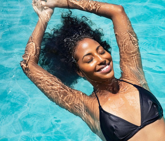 Cheerful woman relaxing in the water with closed eyes 